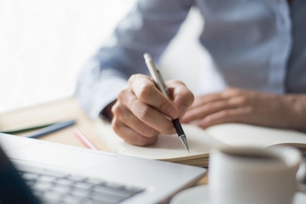 Primer plano de mujer haciendo notas en la oficina