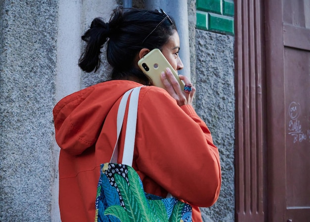 Un primer plano de una mujer joven desde atrás hablando por teléfono