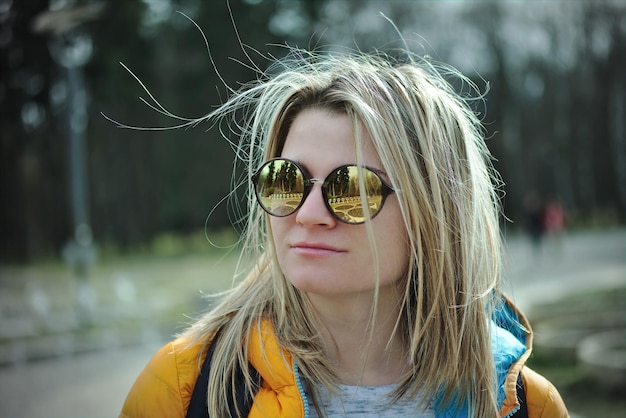 Primer plano de una mujer joven con gafas de sol mientras está de pie al aire libre
