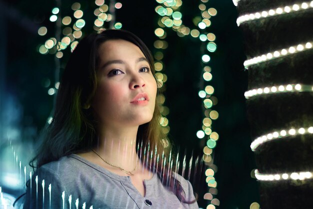 Foto primer plano de una mujer joven en medio de luces iluminadas