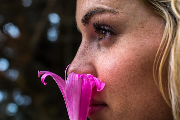 Foto primer plano de una mujer joven con olor a amaryllis rosa