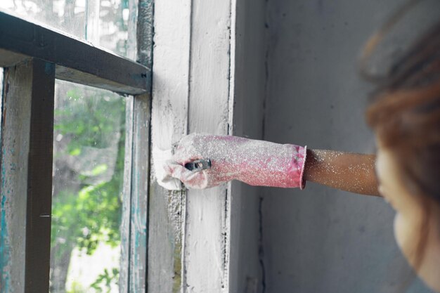 Primer plano de una mujer joven pintando la pared