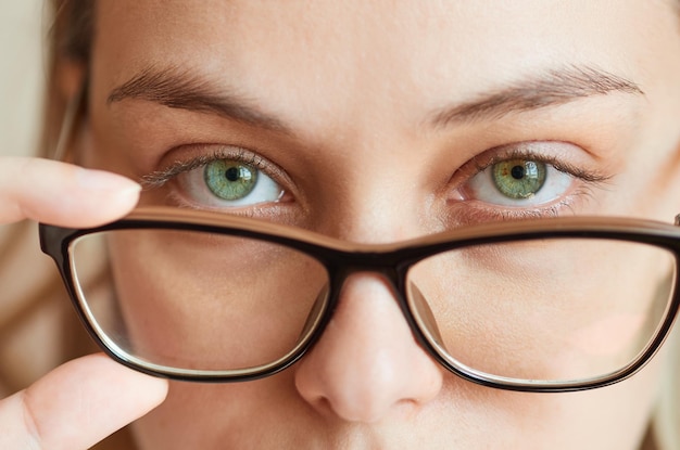 Primer plano de una mujer joven quitándose las gafas Marco de espectáculo de concepto de corrección de visión