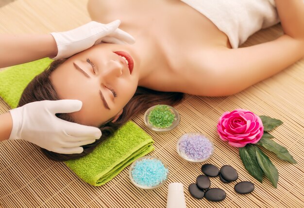 Primer plano de una mujer joven recibiendo tratamiento de spa en el salón de belleza. Spa masaje facial. Tratamiento de belleza facial. Salón de spa.