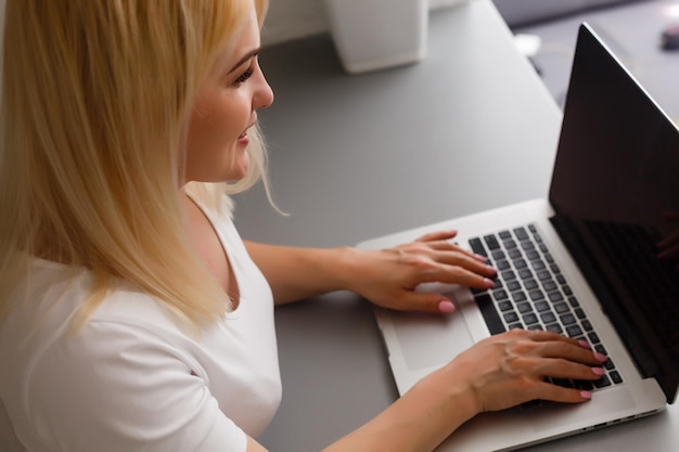 primer plano, de, mujer joven, usar la computadora portátil, en línea, en casa