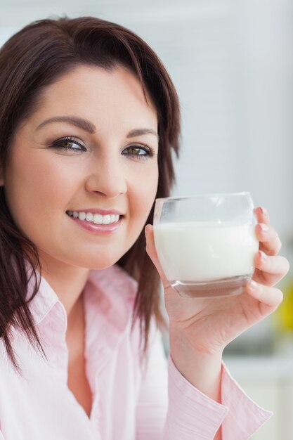 Primer plano de mujer joven con vaso de leche