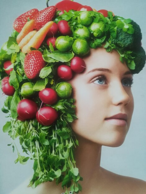 Foto primer plano de una mujer joven con verduras en la cabeza