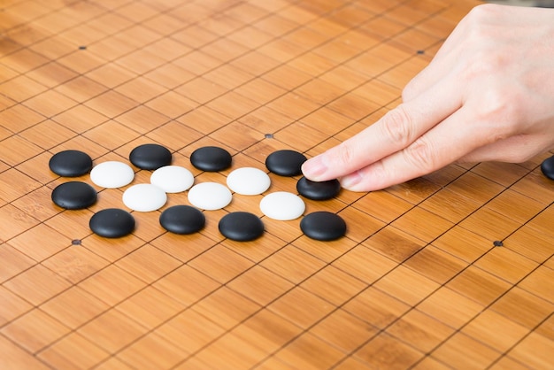 Primer plano de una mujer jugando weiqi atentamente