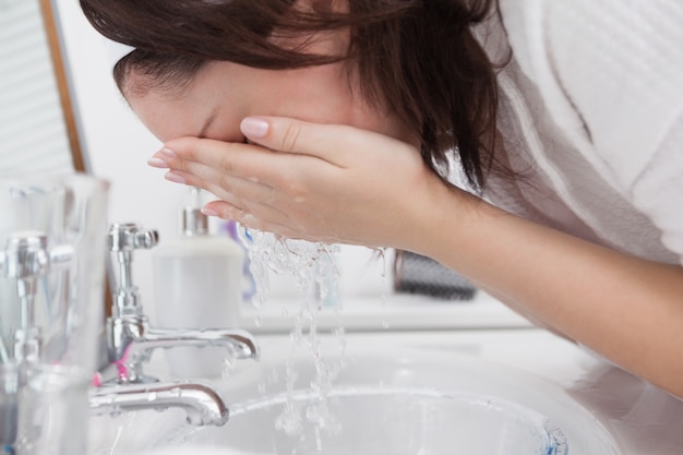 Primer plano de mujer lavando la cara