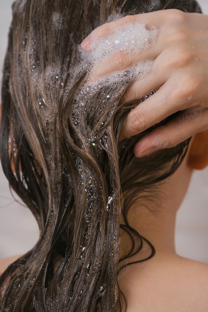 Foto primer plano de la mujer lavándose el pelo