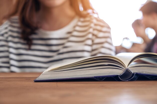 Foto primer plano de una mujer leyendo un libro en la mesa