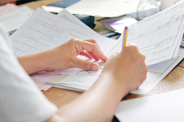 Primer plano de una mujer con un libro trabajando en la mesa