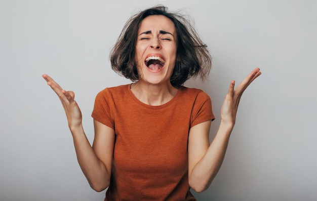 Primer plano de mujer loca frustrada gritando con ansiedad ira y depresión Mujer muy molesta y emocional llorando Niña con cara enojada y furiosa Expresiones y emociones humanas