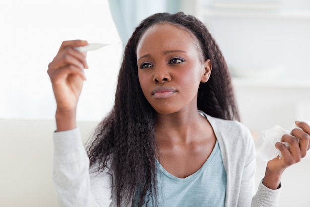 Primer plano de mujer midiendo su temperatura