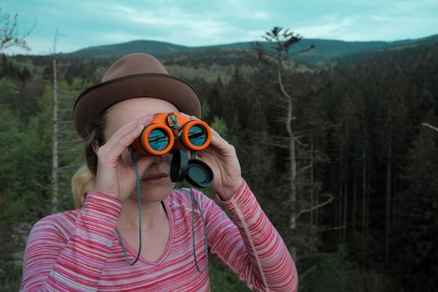 Foto primer plano de una mujer mirando a través de binoculares