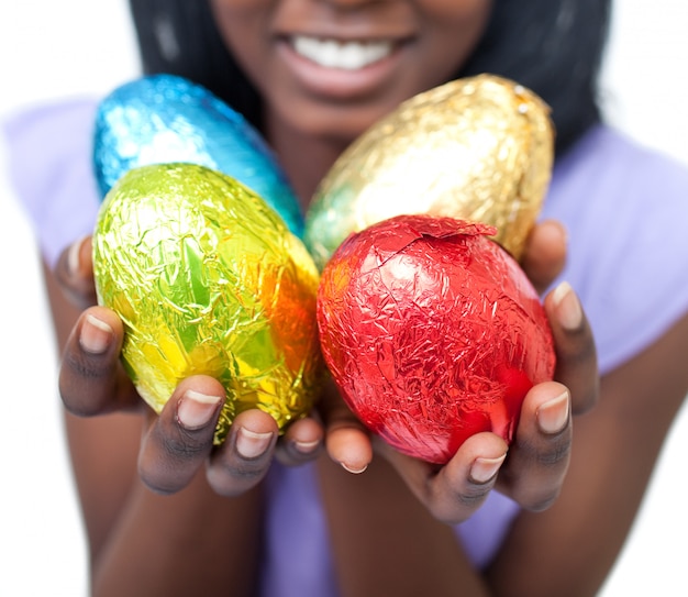 Primer plano de una mujer mostrando coloridos huevos de Pascua