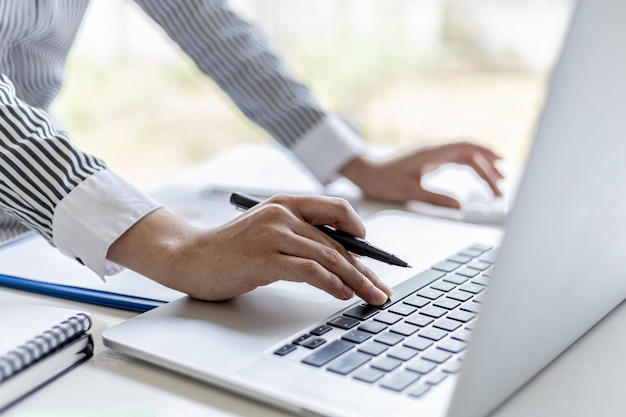 Primer plano Una mujer de negocios que trabaja en una habitación privada, está escribiendo en el teclado de una computadora portátil, utiliza un mensajero para charlar con un compañero. Concepto de uso de la tecnología en la comunicación.