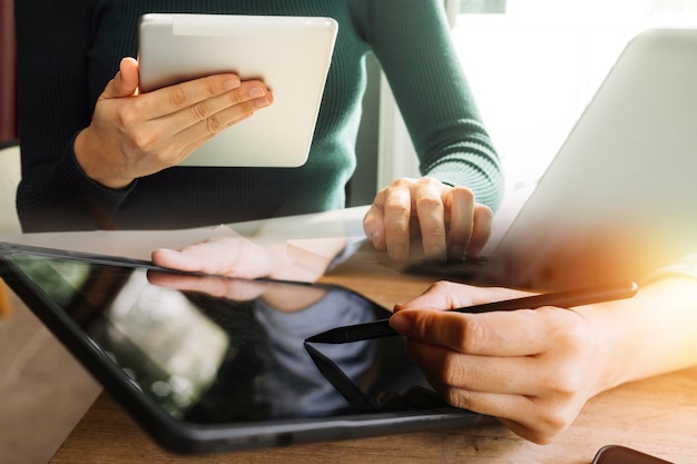 Primer plano de una mujer de negocios que trabaja con un teléfono inteligente y una computadora portátil y una tableta digital en una oficina moderna con un diagrama de icono virtual