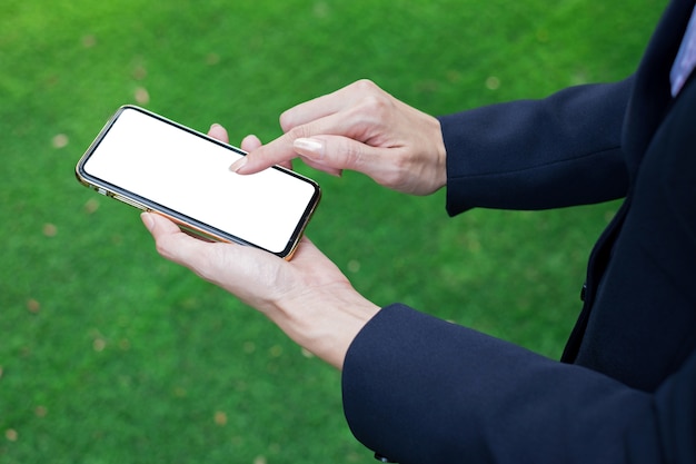 Primer plano, de, mujer de negocios, tenencia, teléfono móvil, con, fondo verde