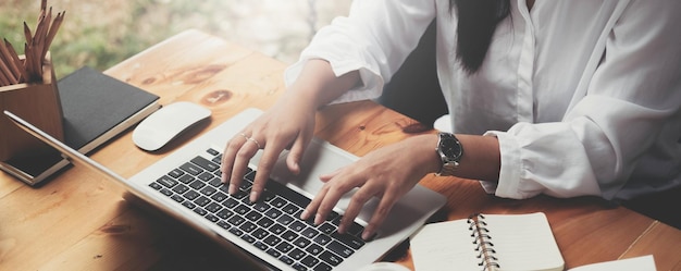 Primer plano de una mujer de negocios trabajando escribiendo en el teclado del portátil en la oficina