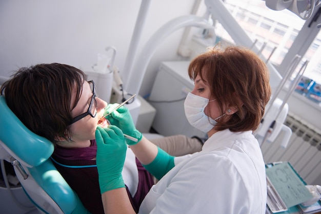 Primer plano de una mujer paciente en el dentista esperando ser revisada con la doctora en el fondo