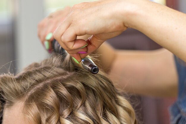 Primer plano de una mujer peluquera haciendo rizos