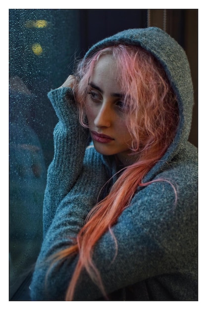 Primer plano de una mujer pensativa con cabello rosado