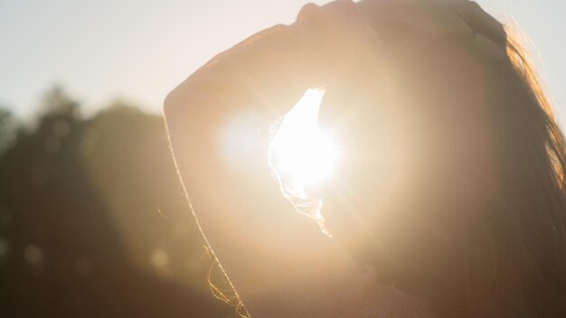 Foto primer plano de una mujer de pie contra el sol