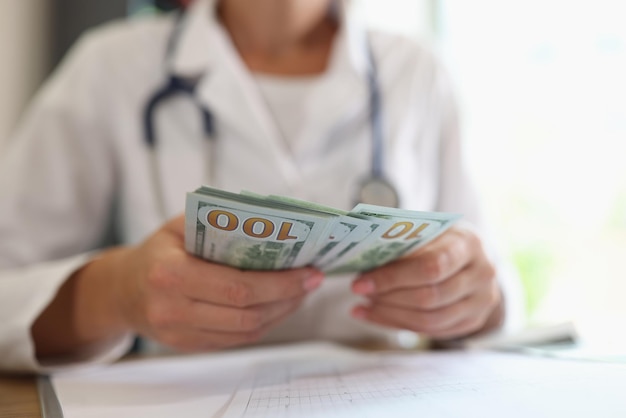 Primer plano de mujer practicante sosteniendo y contando billetes en manos salario del personal médico