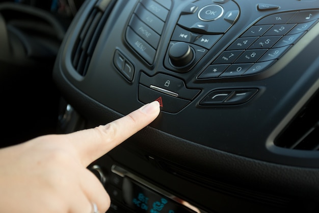 Foto primer plano de una mujer presionando el botón de emergencia del coche