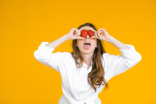 Primer plano de una mujer sexy comiendo fresa fresca Labios sexuales Lápiz labial rojo Concepto de comida saludable