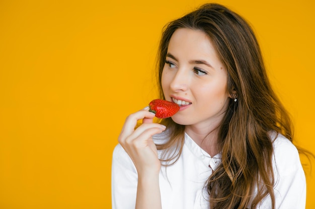 Primer plano de una mujer sexy comiendo fresa fresca Labios sexuales Lápiz labial rojo Concepto de comida saludable