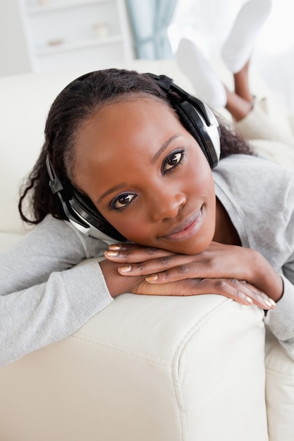 Primer plano de mujer en el sofá disfrutando de la música