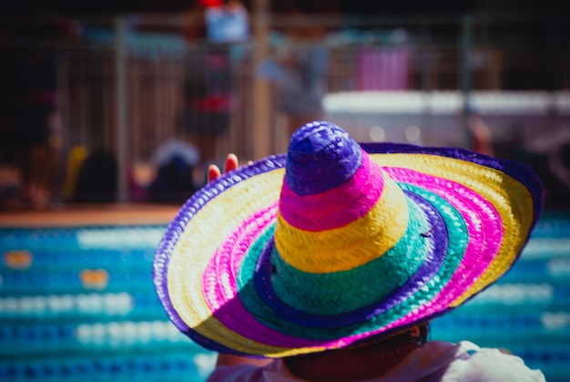 Primer plano de una mujer con un sombrero multicolor al aire libre