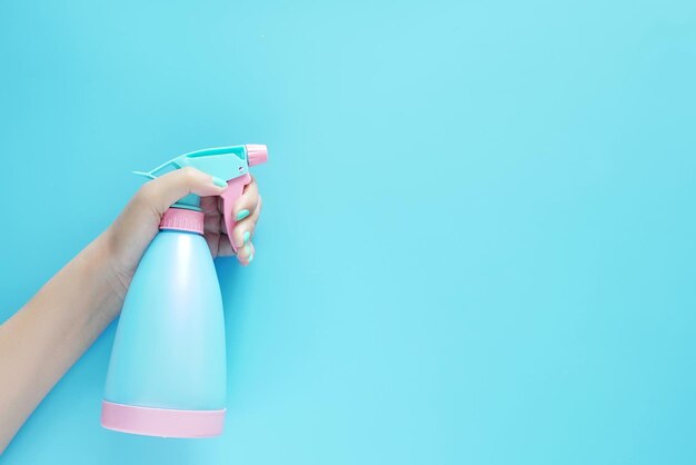 Foto primer plano de una mujer sosteniendo una botella contra un fondo azul