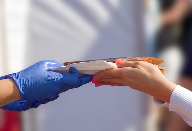 Foto primer plano de una mujer sosteniendo comida en las manos contra una pared blanca