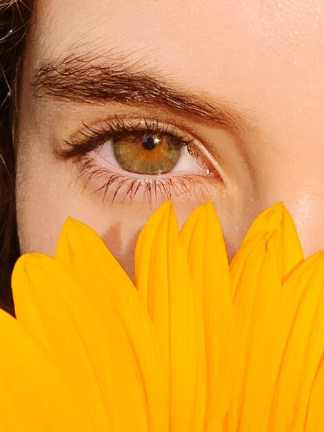 Foto primer plano de una mujer sosteniendo una flor amarilla