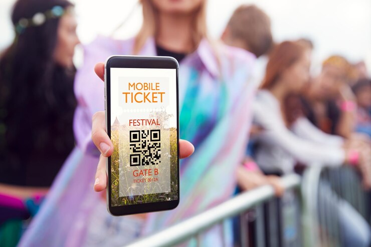Foto un primer plano de una mujer sosteniendo la pantalla de su teléfono móvil ante la cámara mientras llega a la entrada de un festival de música