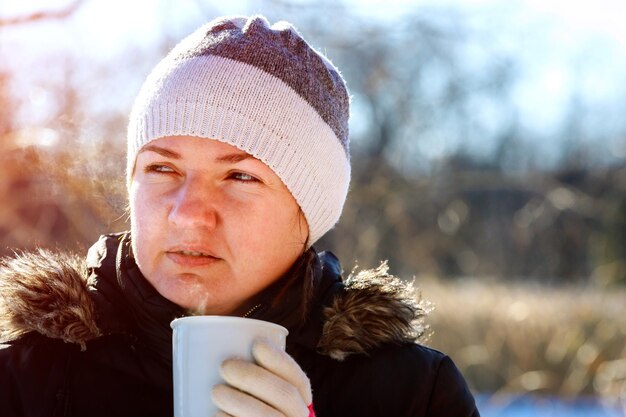 Foto primer plano de una mujer sosteniendo una taza de café durante el invierno