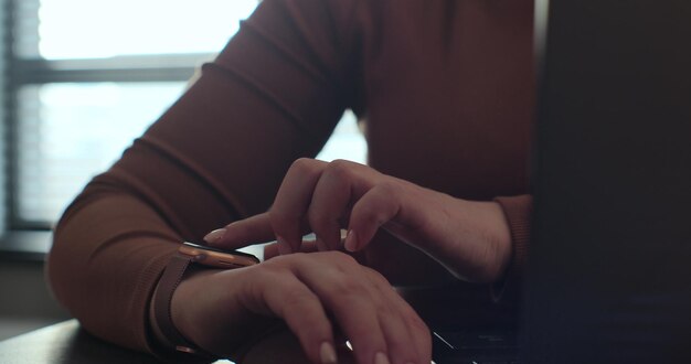 Foto primer plano de una mujer tocando la pantalla de un reloj inteligente deslizando la pantalla del dispositivo en la oficina