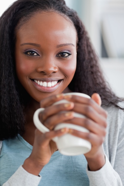 Primer plano de mujer tomando un café en el sofá