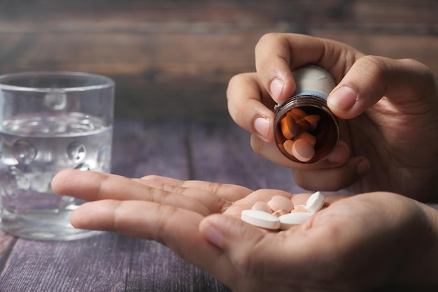 Primer plano de una mujer tomando medicamentos con la mano