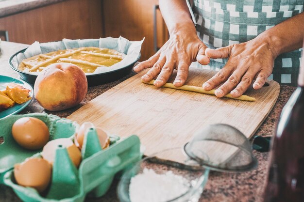 Primer plano de mujer trabajando y cocinando en casa con pasta fresca haciendo un pastel hecho a mano Concepto de preparación de estilo de vida de comida natural Mujer ama de casa haciendo postre de almuerzo saludable con las manos sobre la mesa