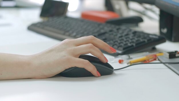 Primer plano de una mujer trabajando en una computadora en la oficina una mujer creativa maneja el mouse de la computadora en el escritorio
