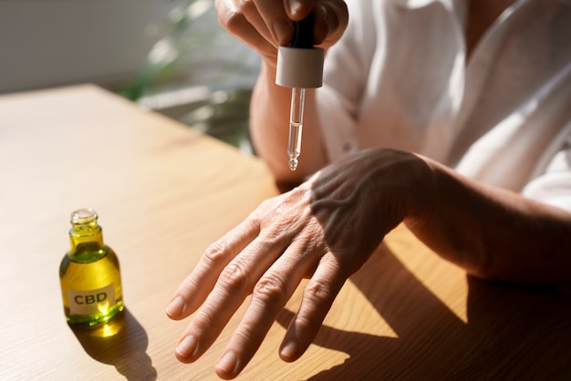 Foto primer plano de una mujer usando aceite de cbd en la mano