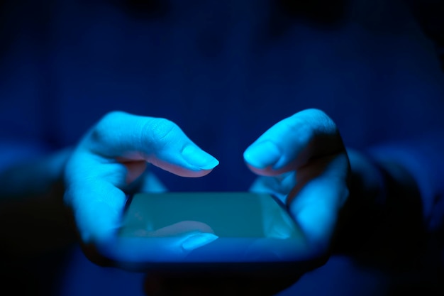 Un primer plano de una mujer usando un teléfono móvil con efecto de luz azul