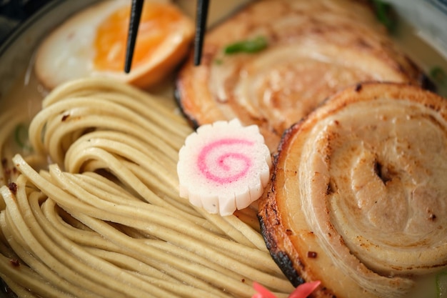 Primer plano de narutomaki en una sabrosa sopa japonesa de ramen con carne de fideos y huevo cocido en un tazón