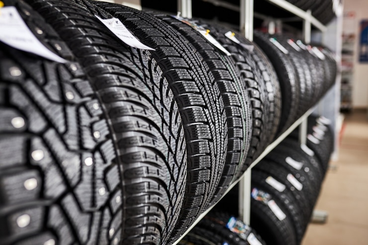 Foto primer plano de neumáticos nuevos en el centro de servicio de reparación de automóviles, neumáticos de invierno nuevos con una banda de rodadura moderna aislada. enfoque selectivo. fondo de pila de neumáticos temporada de invierno, no hay gente