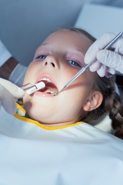 Primer plano de niña con los dientes examinados