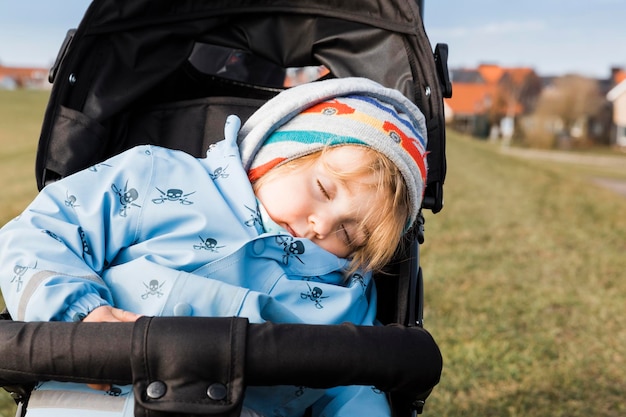 Foto primer plano de una niña durmiendo en un cochecito en el campo